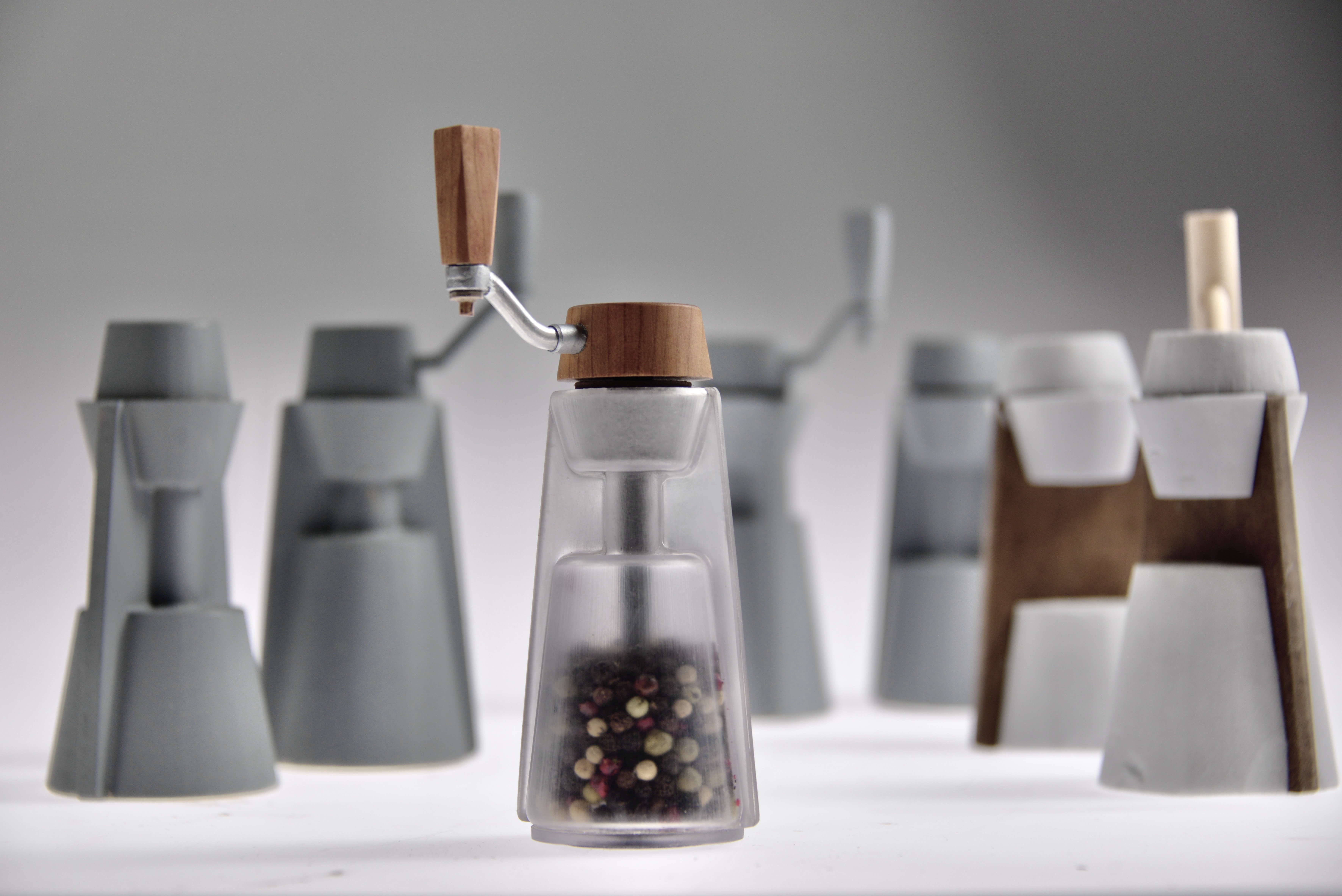 SHI grinder prototypes showing wood, metal, and frosted glass